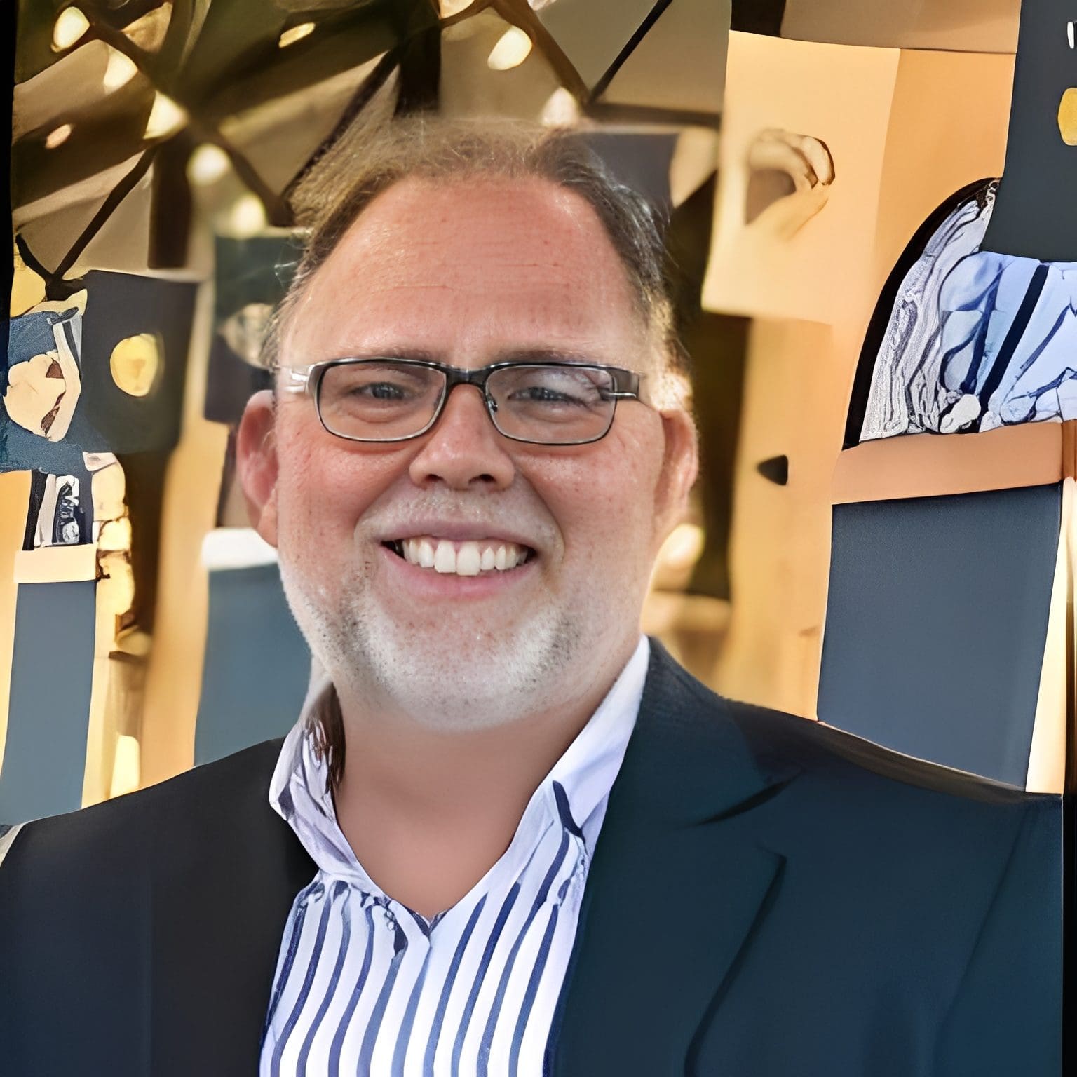 Smiling man in suit and glasses.