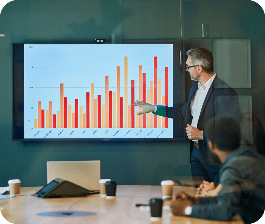 Man presenting bar graph to colleagues.