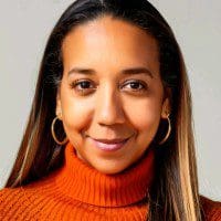 Smiling person in orange turtleneck and earrings.