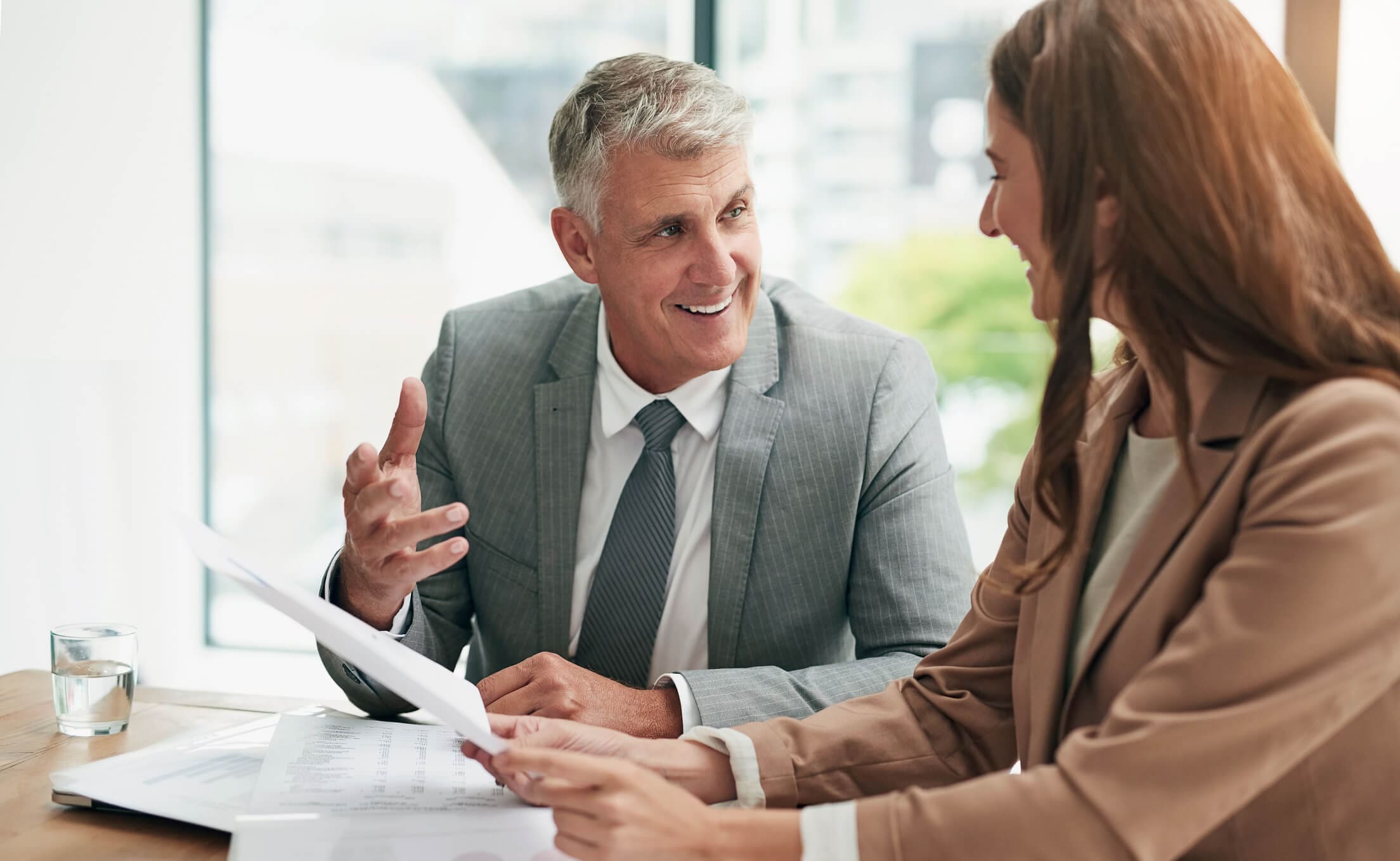 Business meeting with two people discussing documents.